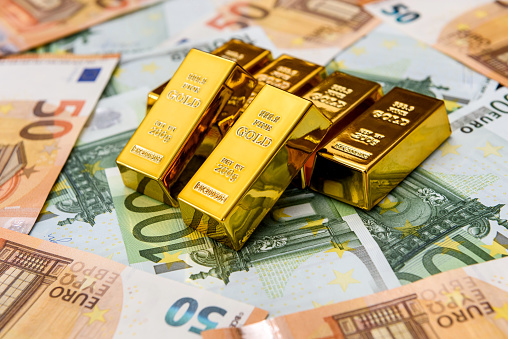 Euro banknotes and gold ingots close up
