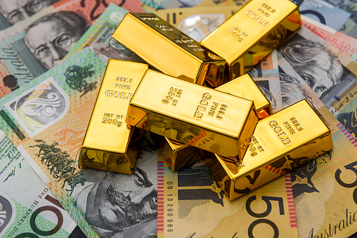 Gold bullion at colorful australian dollar banknotes