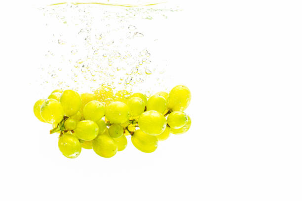 istock Bunch of green grapes sinking into crystal clear water. 1163741525