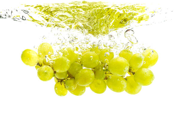 istock Bunch of green grapes sinking into crystal clear water. 1163741535