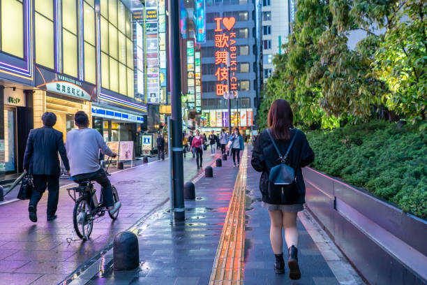 eine junge frau erkundet shinjuku kabukicho - shinjuku bezirk stock-fotos und bilder