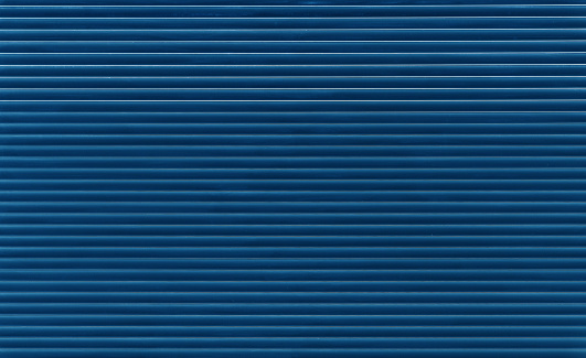 Background texture of dark blue indigo color painted horizontal metal window roller shutter blinds