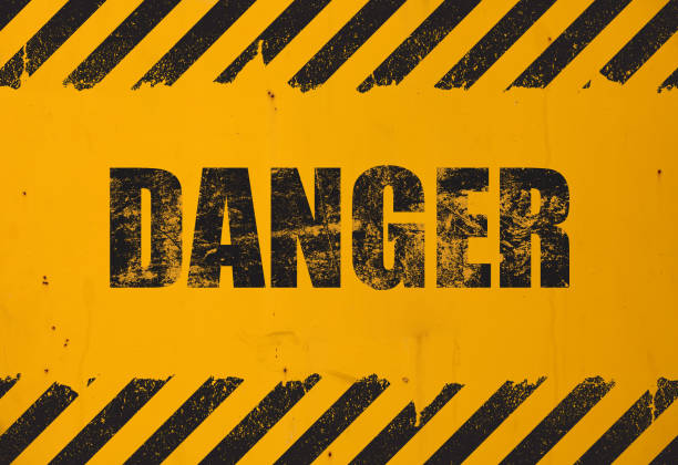 Yellow background with black grunge danger sign Old yellow weathered painted background with grunge black danger sign and stripes warning sign photos stock pictures, royalty-free photos & images