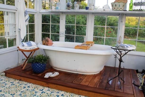 glückliche und entspannte reife frau genießen ihre schöne outdoor-badewanne - durchnaesst stock-fotos und bilder