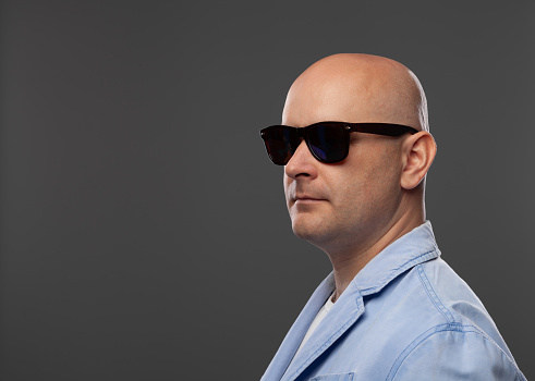 Bald bearded man in sunglasses on white background