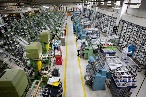 Latin American people operating machines at a textile factory - industrial concepts