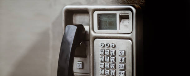 rendição suja de um telefone público operado moeda que mostra o teclado metálico e o monofone plástico. rapidamente tornando-se um método de comunicação desatualizado e obsoleto. ideal como um banner. quarto para a cópia - coin operated pay phone telephone communication - fotografias e filmes do acervo