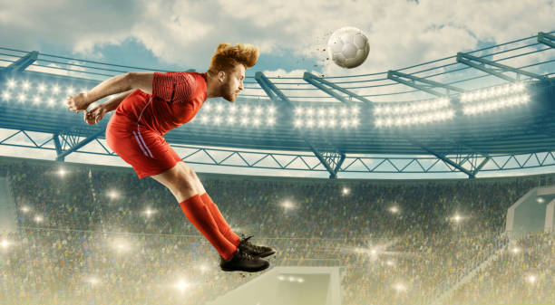 istock Soccer player heading a ball on a stadium 1163749838