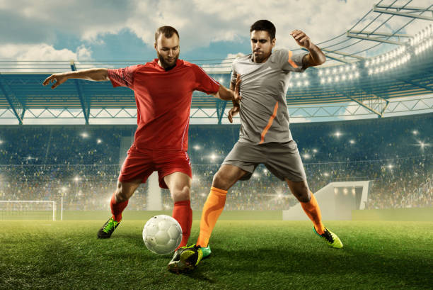 due calciatori professionisti combattono per una palla su uno stadio - kick off soccer player soccer kicking foto e immagini stock