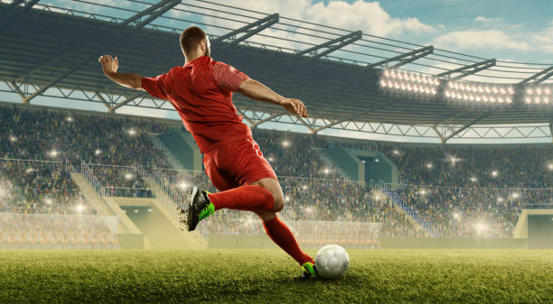 Soccer player kicks a ball Professional soccer player with a ball in action. Soccer stadium with tribunes and fans cheering. Sports event taking a shot sport photos stock pictures, royalty-free photos & images