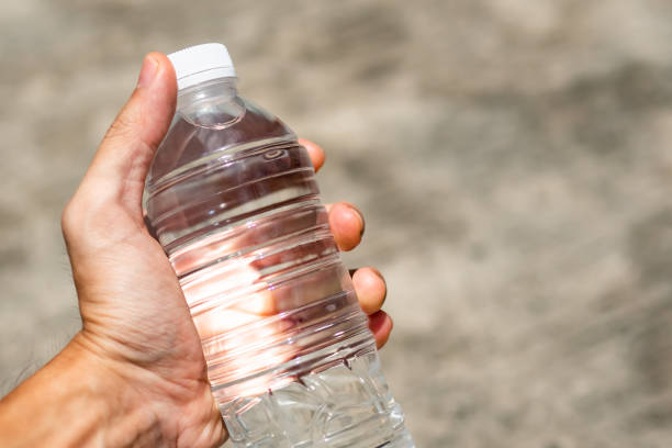 istock Men hand holding water bottle in hot sunlight 1163755151