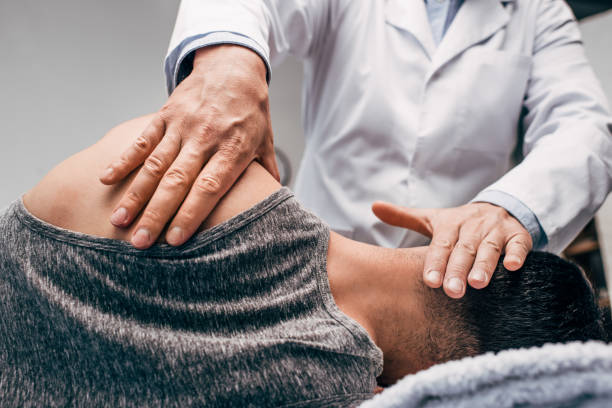 istock chiropractor in white coat massaging neck of man 1163756369