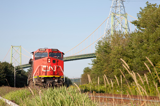 Halifax, Nova Scotia- August 2, 2017: A CN railway train runs along underneath the MacDonald bridge in Halifax