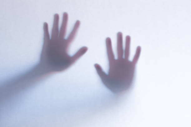 istock Defocused scary ghost hands behind a white glass background 1163761281