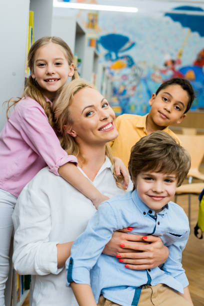 istock cheerful kid hugging attractive woman near multicultural boys 1163762619