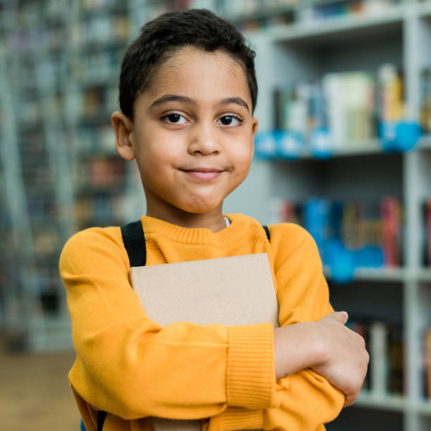 istock cute african american boy smiling while holding book 1163762623