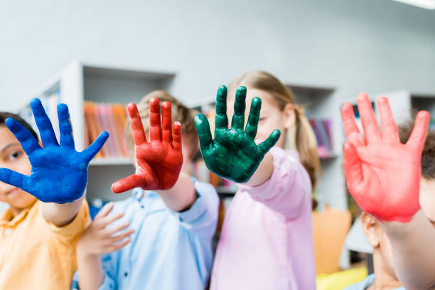 istock selective focus of multicultural kids covering faces with colorful hands 1163762654