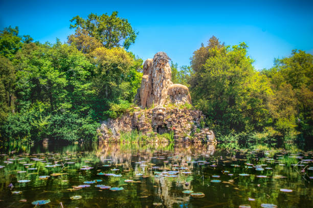 villa demidoff pratolino parque y la estatua del colosso del appennino coloso con estanque lleno de nenúfares y hojas - giambologna fotografías e imágenes de stock