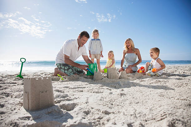 familia hacer castillos de arena en la playa - summer beach vacations sand fotografías e imágenes de stock