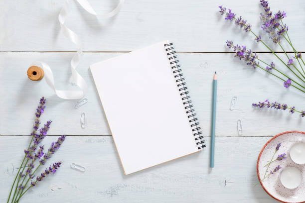 istock Empty paper notepad, pen, lavender flower, ribbon on rustic blue wooden desk. Flat lay, top view, overhead. Fashion blogger workspace, feminine office desk. 1163768478