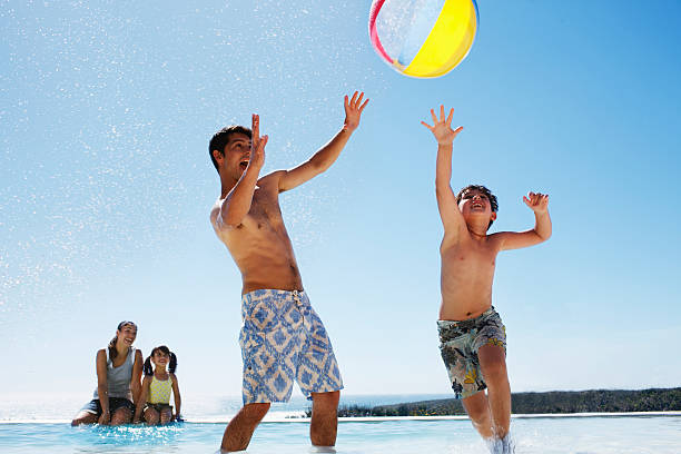 famille jouant avec le ballon dans la piscine - beach ball swimming pool ball child photos et images de collection