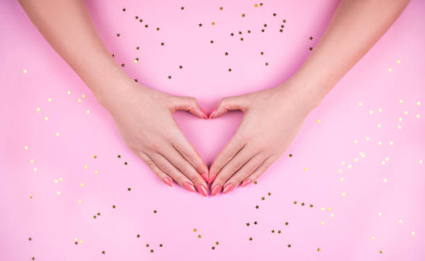 istock Woman's hand with Pink manicure making heart. 1163769324