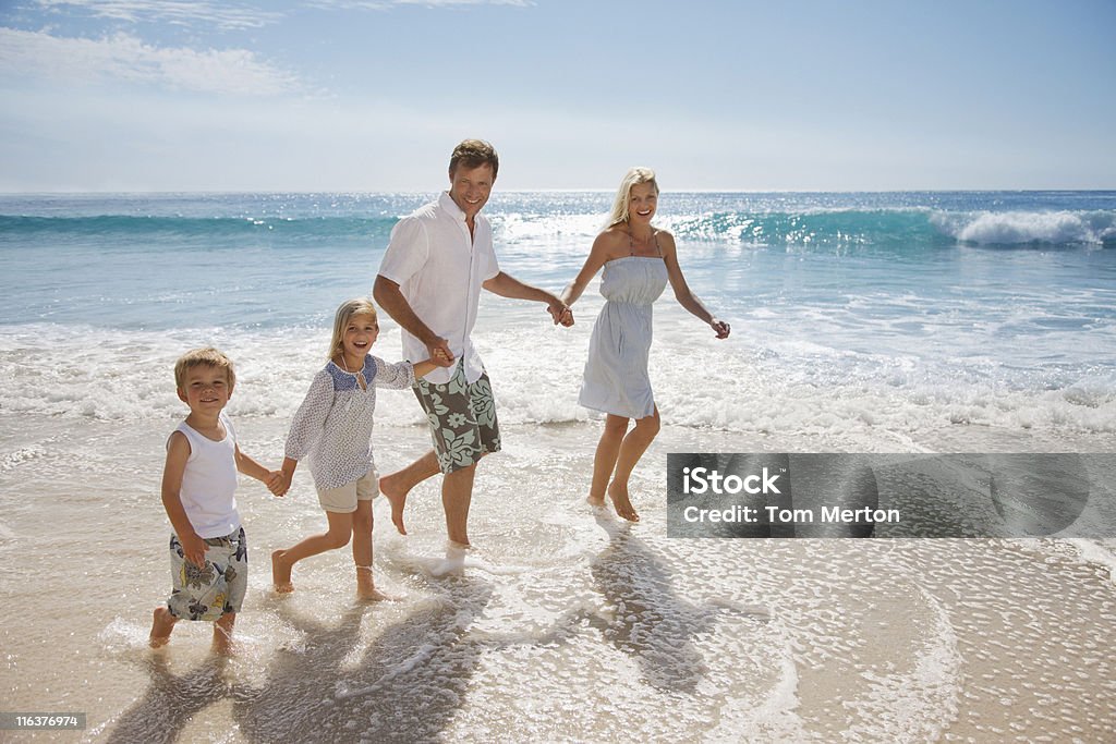 Famille Marcher dans l'eau dans l'océan - Photo de Famille libre de droits