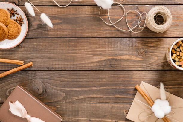 istock Flatlay autumn composition. Frame of cinnamon sticks, rope, envelope, cookies, tea cup, gift box on wooden background. Flat lay, top view, copy space. Cozy home desk, hygge, autumn fall concept 1163770188