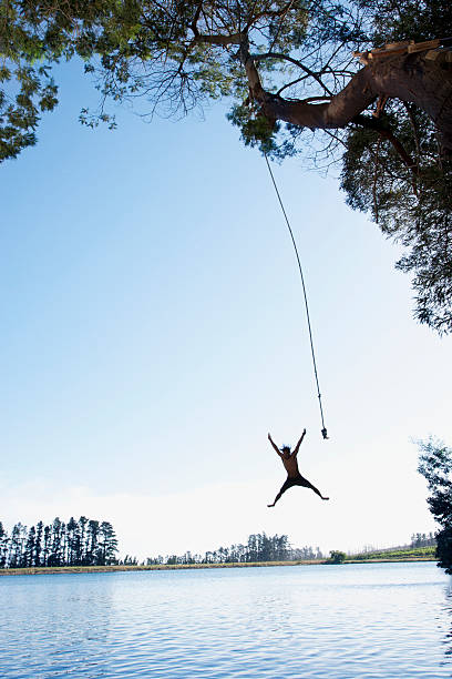 Man Jumping From Rope Swing Into Lake Stock Photo - Download Image Now - Rope  Swing, Lake, Jumping - iStock
