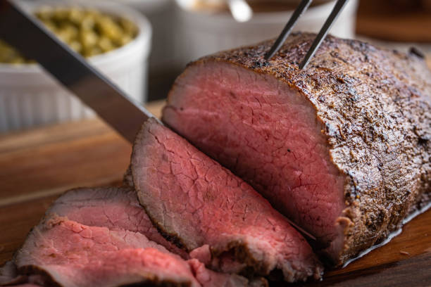 istock slicing eye of round roasted beef with knife 1163771909