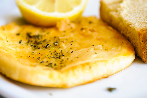 Saganaki - a Greek dish of kefalograviera, kasseri, kefalotyri, or feta cheese, pan seared and served with lemon and bread