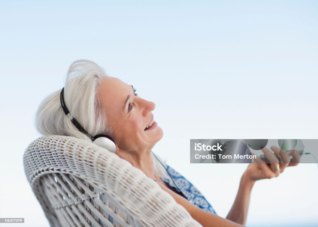 Senior femme écoutant de la musique sur lecteur mp3 - Photo de Musique libre de droits