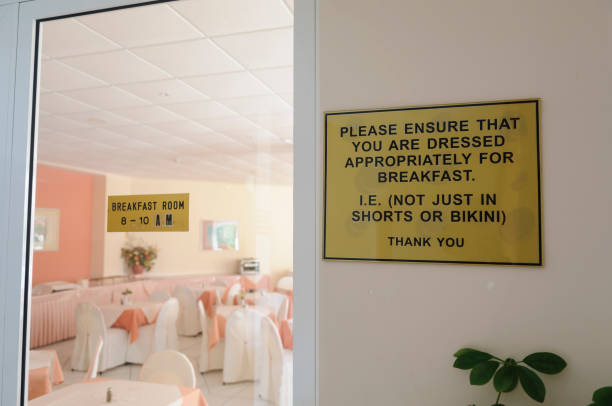 Sign outside a dining room in a hotel, asking patrons to ensure they are dressed appropriately for breakfast Sign outside a dining room in a hotel, asking patrons to ensure they are dressed appropriately for breakfast breakfast room stock pictures, royalty-free photos & images