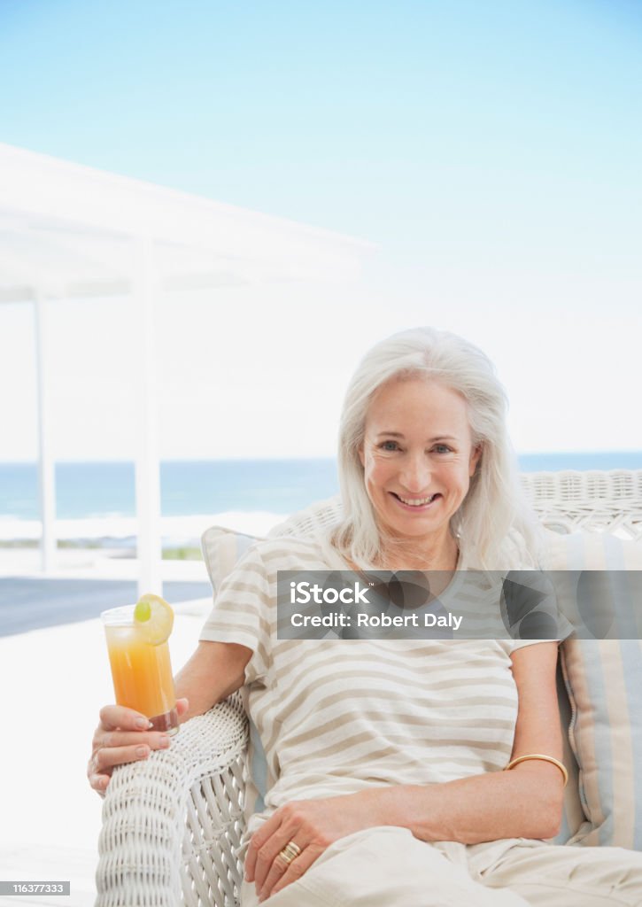 Senior Femme buvant un cocktail sur la terrasse - Photo de Femmes libre de droits