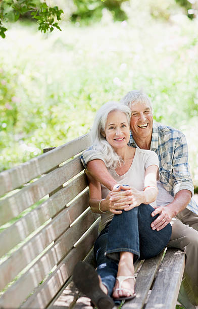 senior couple hugging on bench - 60 69 jaar fotos stockfoto's en -beelden