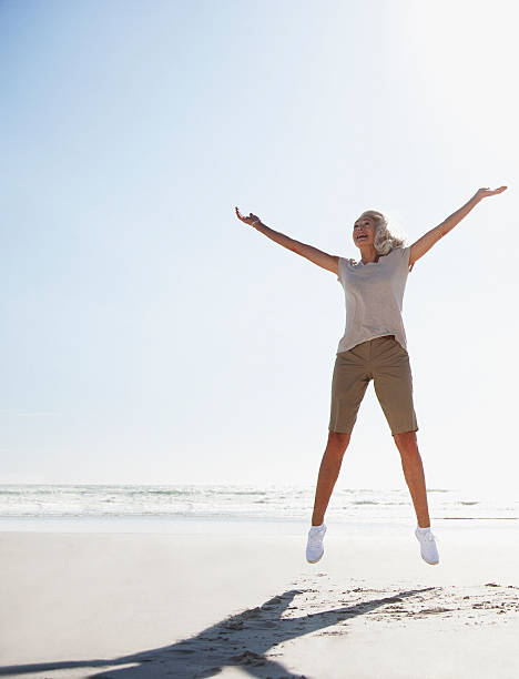 해변의 뛰어내림 여자 노인 - jumping freedom women beach 뉴스 사진 이미지