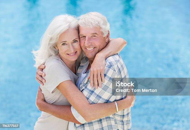 Casal Idoso Agarrar Ao Lado Da Piscina - Fotografias de stock e mais imagens de 60-64 anos - 60-64 anos, 65-69 anos, Abraçar