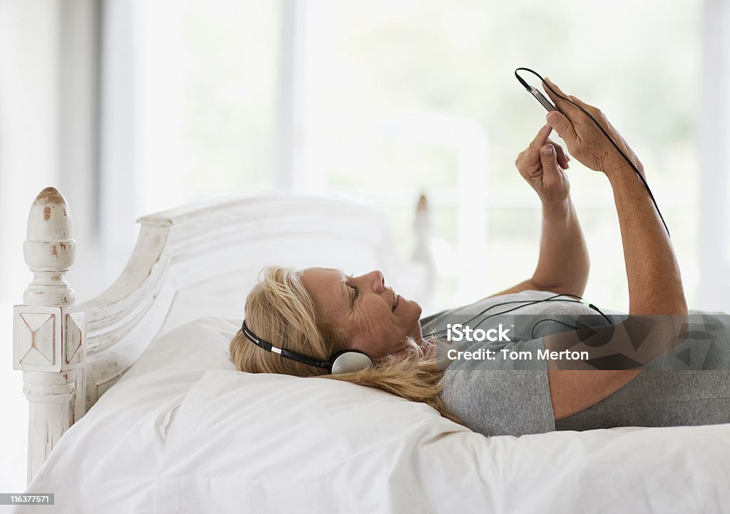 여자 힐튼의 침대 및 음악을 수 있는 mp3 플레이어 - 로열티 프리 음악 스톡 사진