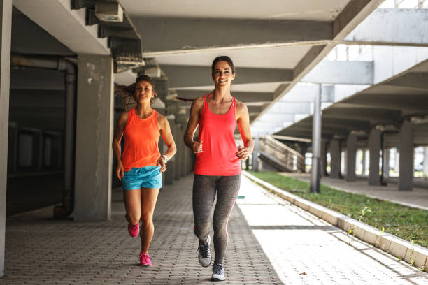 istock Two female runners jogging around the city. 1163776041