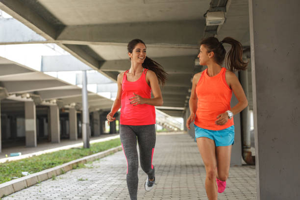 istock Two female runners jogging around the city. 1163776073
