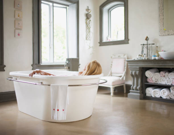 donna nella vasca da bagno - relaxation women bathtub bathroom foto e immagini stock