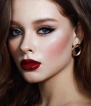 Lipstick, woman and makeup in studio for skincare, cosmetics and aesthetics. Young model face, red colorful lips and beauty product for luxury fashion, salon and cruelty free facial balm application