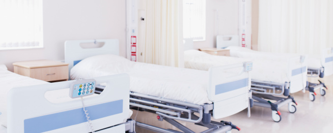 Background image of hospital room interior with bed against pale blue wall, copy space