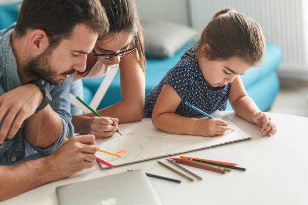istock Father and mother teach daughter to draw. 1163779991