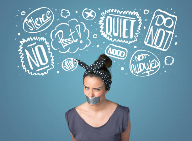 istock Young woman with glued mouth and thought clouds 1163780058