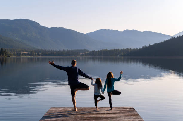 famiglia che pratica yoga all'aperto - mind trip foto e immagini stock