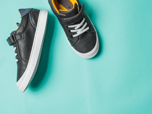 istock Gray and yellow sneakers on blue background 1163781388