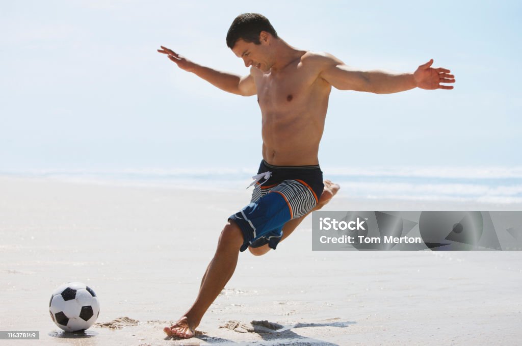 Homem chute a bola de futebol na praia - Foto de stock de Futebol royalty-free