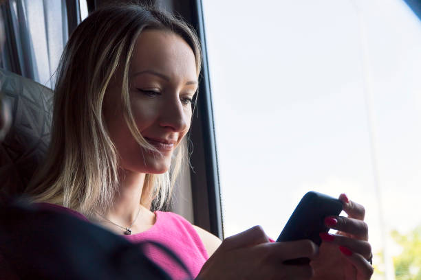 istock Woman using mobile phone on her bus trip 1163782029