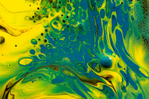 Blue, green and yellow colored and dotted abstract paint background texture.